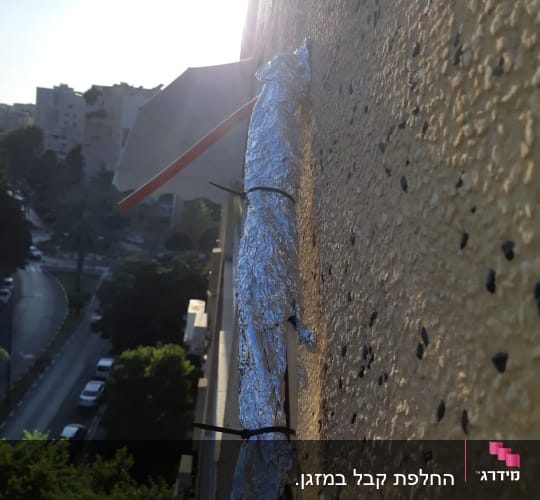 צינור מיזוג מכוסה בנייר כסף על קיר חיצוני